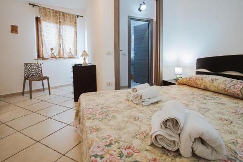 a bedroom with a bed with towels on it at Sardinia's house IUN R5500 in Gonnesa