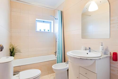 a white bathroom with a sink and a toilet at Stunning View Apartament by BnbHost in Vila Nova de Gaia