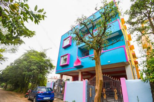 a blue building with a car parked in front of it at OYO Maa Home Stays 5 in Bhubaneshwar
