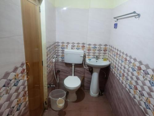 een badkamer met een toilet en een wastafel bij shanthi home in Puttaparthi