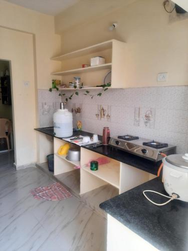 een keuken met een aanrecht en een fornuis top oven bij shanthi home in Puttaparthi