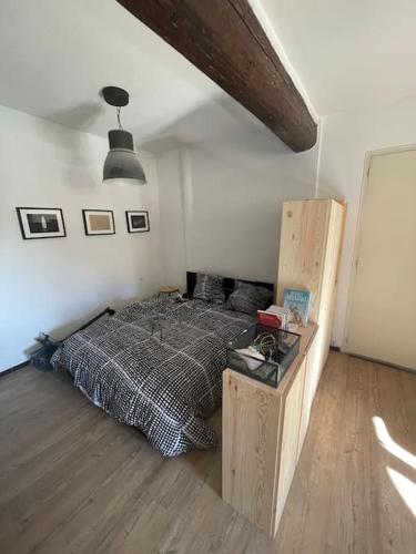 Schlafzimmer mit einem Bett und Holzboden in der Unterkunft Appartement cœur du centre-ville in Avignon