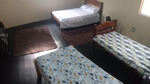 1 dormitorio con 2 camas y 2 alfombras en Casa de Praia Mosqueiro - São Francisco, en Belém