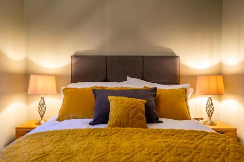 a bedroom with a large bed with yellow pillows at 2 Rowntree House in York