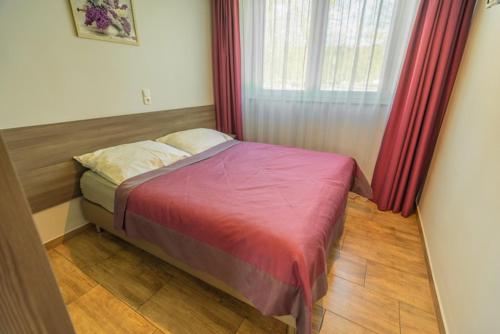 una camera da letto con un letto con tende rosse e una finestra di Ostoja a Turawa