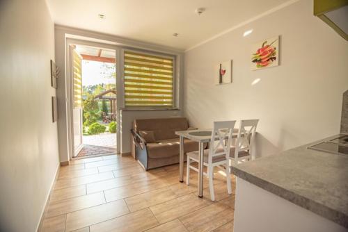 a kitchen and living room with a table and chairs at Ostoja in Turawa