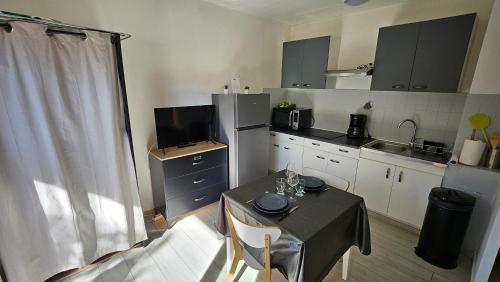 une petite cuisine avec une table et une salle à manger dans l'établissement Amélie-les-Bains-Palalda Résidence Las Hortes, à Amélie-les-Bains-Palalda