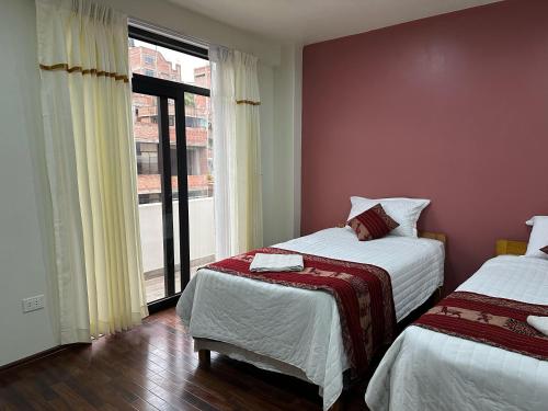 1 Schlafzimmer mit 2 Betten und einem großen Fenster in der Unterkunft LA CASA REAL in Puno