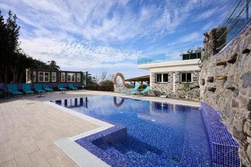 uma piscina com cadeiras azuis e uma casa em Casas Maravilha by Madeira Sun Travel em Calheta