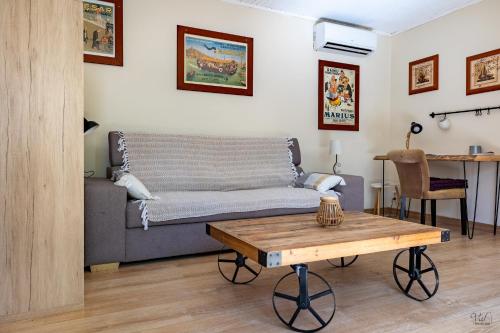 een woonkamer met een bank en een tafel bij La Halte Provençale vaste gîte T1 avec jardin entre mer et collines in Roquevaire
