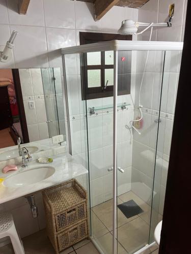 uma casa de banho com uma cabina de duche em vidro e um lavatório. em Aconchego Toque Toque em São Sebastião