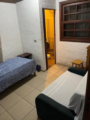 um quarto com duas camas e uma porta para uma casa de banho em Aconchego Toque Toque em São Sebastião