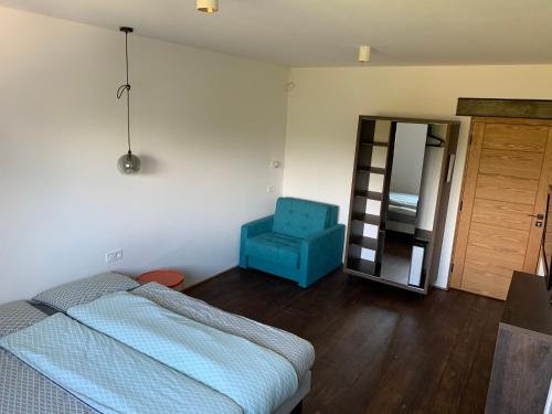 a bedroom with a bed and a blue chair at Black House 88 in Ustroń