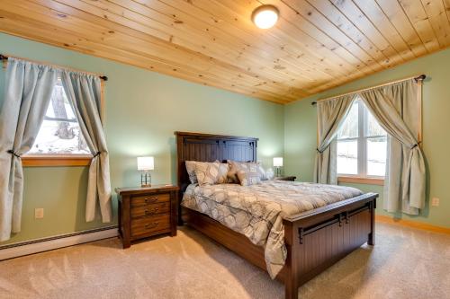 ein Schlafzimmer mit einem großen Bett und zwei Fenstern in der Unterkunft Peaceful Stark Cottage with Deck on South Ponds! in Dummer