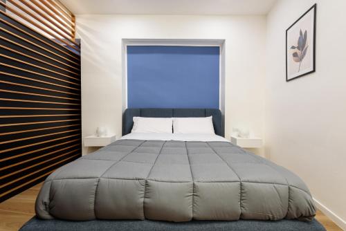 una camera da letto con un grande letto con una grande finestra di APPARTAMENTI VALLETTI ERCOLANO a Ercolano