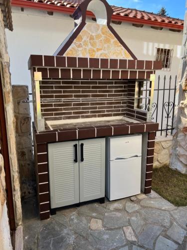 a barbecue grill in front of a house at Heraklia villa sea view pool & jacuzzi in Nea Iraklia
