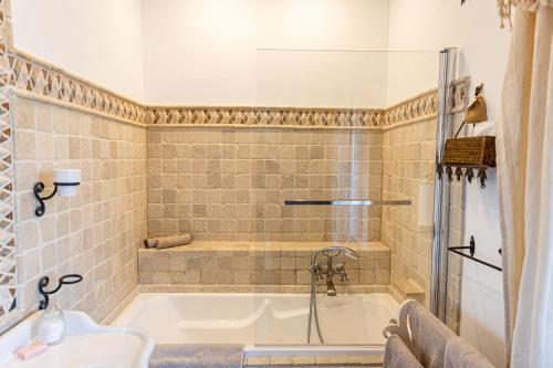 a bathroom with a tub and a sink at Maison Bournissac in Noves