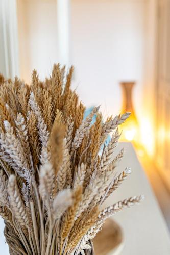 a vase filled with ears of wheat sitting on a table at Maison Bournissac in Noves
