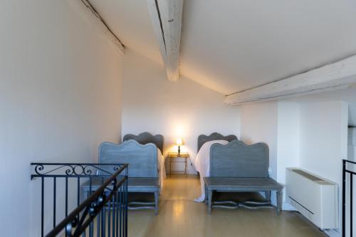 a room with two beds and a table with a lamp at Maison Bournissac in Noves
