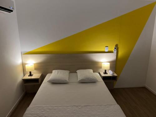 a bedroom with a large bed with two lamps at Mova Express Hotel - CAMPINAS in Campinas