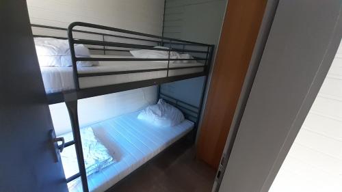 a bunk bed with white sheets and pillows on it at Ferienhaus Uelsen in Uelsen
