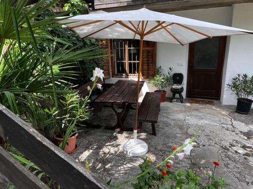 a patio with a wooden table and an umbrella at Ferienwohnung Burgfrieden Brixen with BrixenCard in Brixen