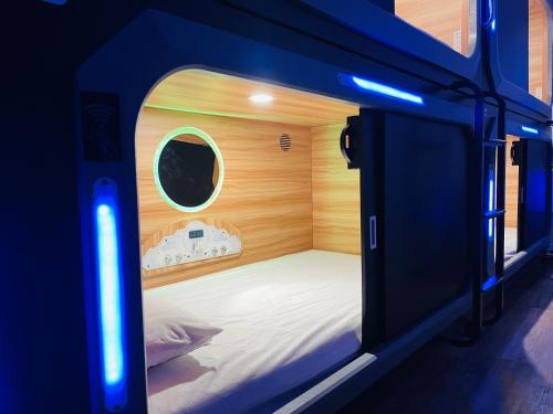 KAMA CENTRAL PARK في نيويورك: غرفة نوم صغيرة مع سرير في غرفة مع أضواء زرقاء