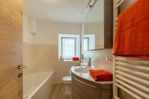 ein Badezimmer mit einem Waschbecken, einem WC und einem Spiegel in der Unterkunft Ferienwohnung Burgfrieden Brixen with BrixenCard in Brixen