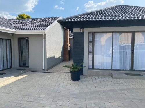 a house with a window and a potted plant at StaySure Guesthouse in Alberton