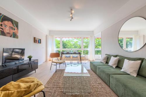 a living room with a green couch and a table at Spacious 3 bedroom apartment & private parking! in Lambersart