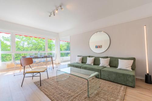 - un salon avec un canapé vert et une table dans l'établissement Spacious 3 bedroom apartment & private parking!, à Lambersart
