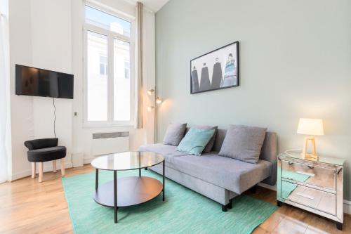 ein Wohnzimmer mit Sofa und Tisch in der Unterkunft Functional flat close to the station in Lille