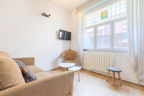 a living room with a couch and a window at Functional apartment in the center of Lille in Lille