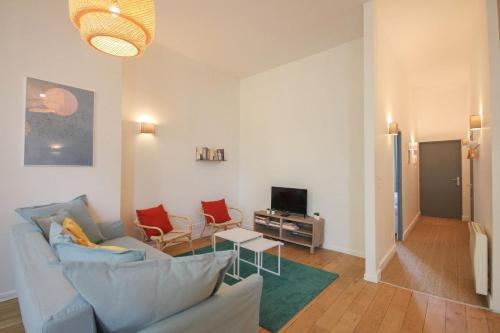 sala de estar con sofá, sillas y TV en 2-bedroom flat + private car park., en Lille