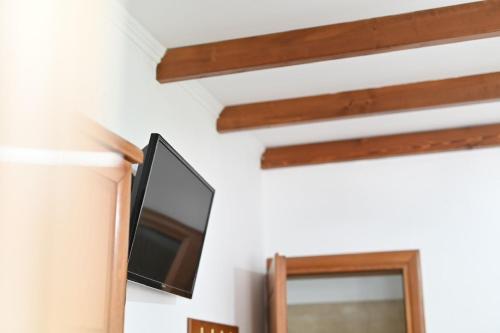 TV colgada en una pared junto a una ventana en Guesthouse Agnandi, en Kato Loutraki