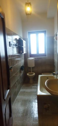 baño con lavabo y aseo y ventana en La casa di Zia Ada, en Bovalino Superiore