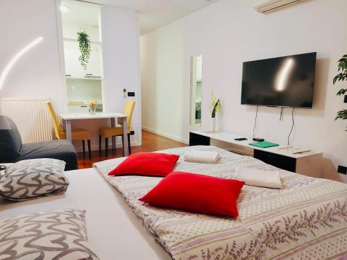 Habitación con 2 camas con almohadas rojas. en Nova Galerija Studio App Bella,Lara,Katy en Zagreb