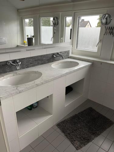a bathroom with two sinks and two mirrors at Caros Zimmer Gladbeck in Gladbeck