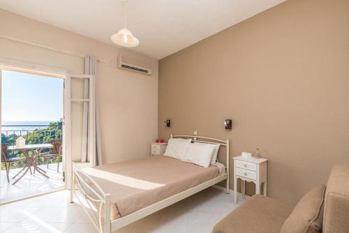 1 dormitorio con 1 cama y balcón en Apartments and studio with swimming pool and Sea View in Pelekas Beach, Corfu, en Pelekas