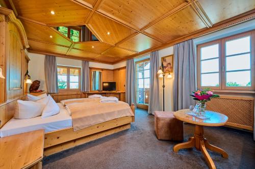 ein Schlafzimmer mit einem großen Bett und einer Holzdecke in der Unterkunft Hotel Happinger Hof in Rosenheim