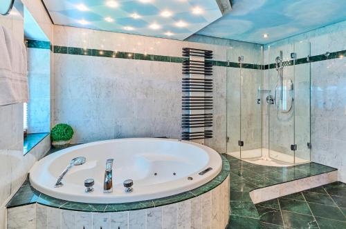 łazienka z wanną i prysznicem w obiekcie Hotel Happinger Hof w mieście Rosenheim