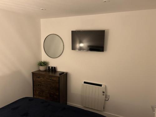 a bedroom with a mirror and a dresser and a tv at Lovely 1-Bed Apartment in Glastonbury in Glastonbury