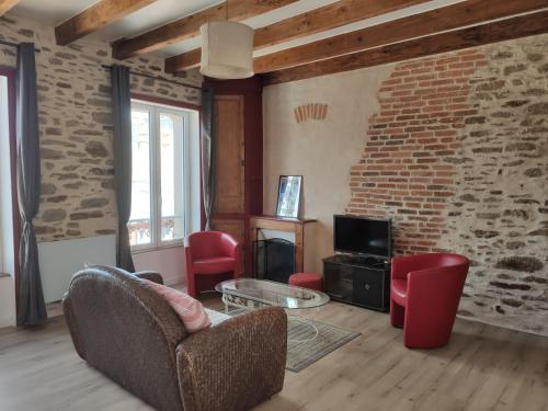 - un salon avec des chaises rouges et un mur en briques dans l'établissement Duplex à 200m du Port d'arrivé, au Palais