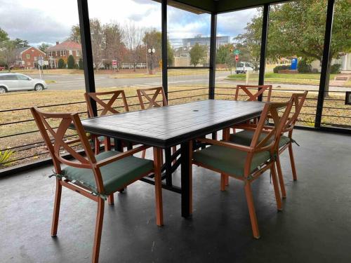 a wooden table and chairs in a porch with a view of a street at Chic 50s Time Capsule Downtown/OU Med/OK Capitol in Oklahoma City