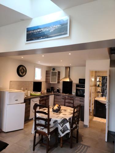 une cuisine avec une table et des chaises dans une pièce dans l'établissement Les gites PENTY de KERROYAL, à Garlan