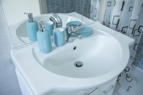 a bathroom sink with blue cups and a mirror at Strambio28 in Milan
