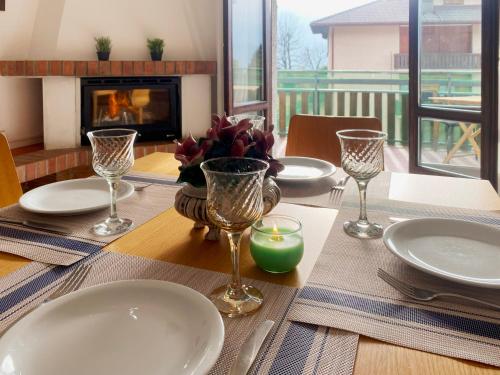 una mesa con platos y vasos en una mesa con chimenea en Spacious apartment with terrace with mountain view en Moggio