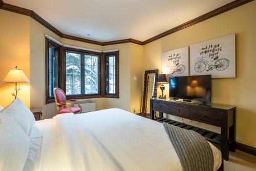 um quarto com uma cama, uma secretária e uma televisão em Tremblant Prestige-Bondurant 95-10 em Mont-Tremblant