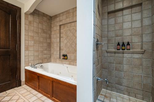 uma casa de banho com banheira e algumas garrafas de vinho em Tremblant Prestige-Bondurant 95-10 em Mont-Tremblant
