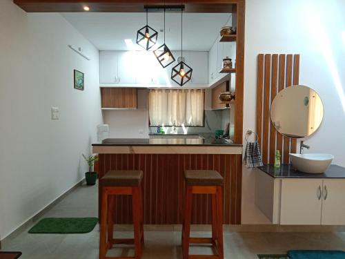 a kitchen with a sink and a counter with stools at Casa Branca Retreat in Varkala